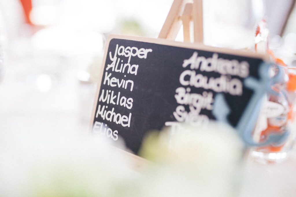 A decorative chalkboard displaying names at a refined indoor gathering.